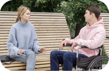 Bendruomeninių paslaugų plėtra – moteris bendrauja su vaikinu vežimėlyje, skatinant žmonių su negalia socialinę įtrauktį ir savarankiškumą